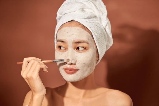 woman applying clay mask